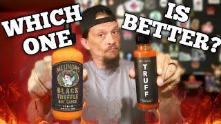 Man holds two bottles of hot sauce with 