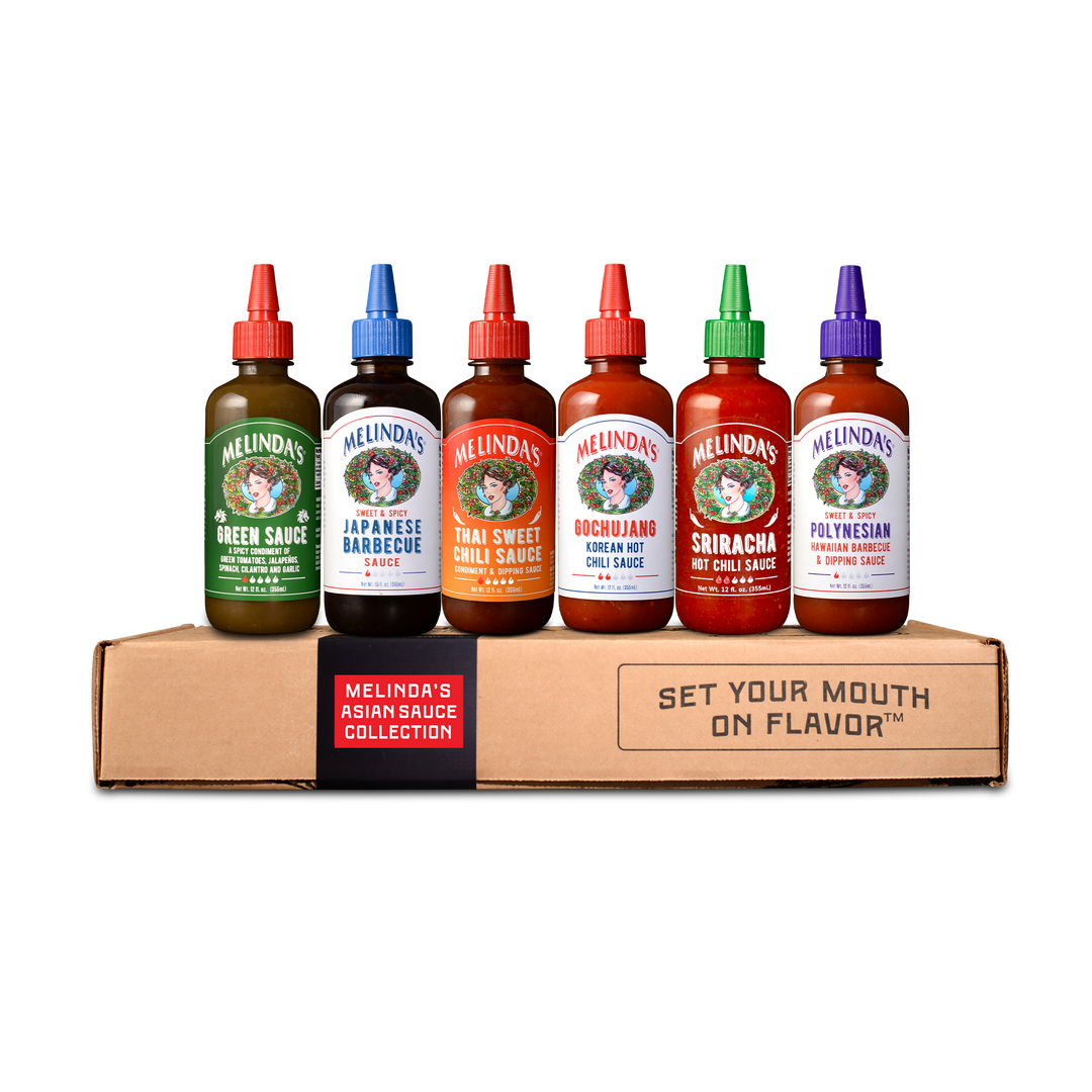 Six Melinda's hot sauce bottles in colorful packaging displayed on cardboard box labeled "Asian Sauce Collection"
