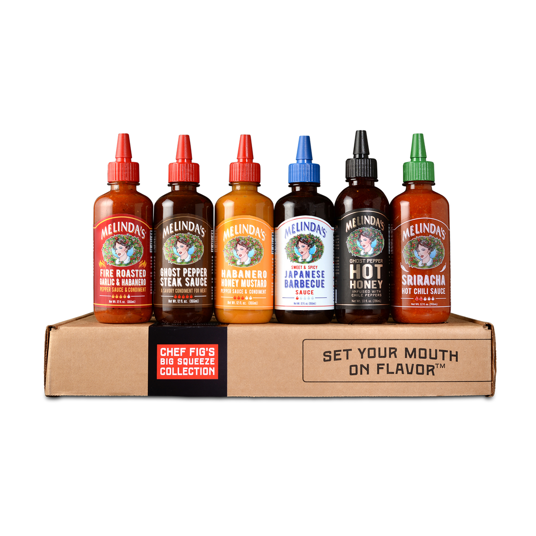 Six bottles of Melinda's hot sauce in various flavors displayed on a cardboard box labeled "Chef Fig's Big Squeeze...
