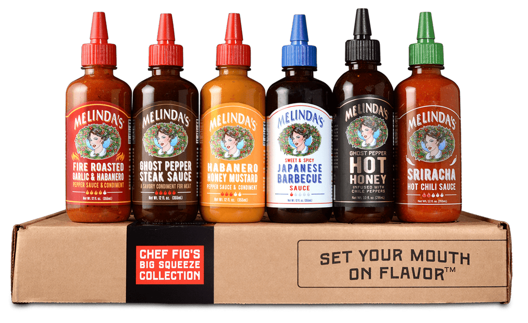 Six Melinda's hot sauce bottles with colorful caps in cardboard gift box labeled "Chef Fig's Big Squeeze Collection"
