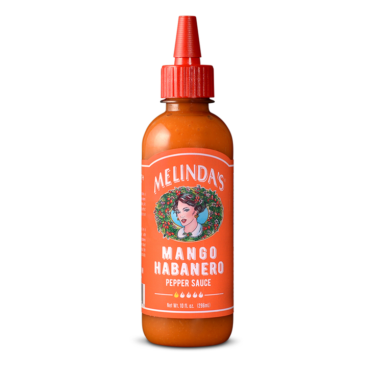 Melinda's Mango Habanero Pepper Sauce bottle with orange label featuring woman's portrait, red squeeze cap, 10 fl oz