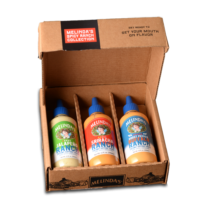 Open cardboard box containing three Melinda's ranch sauce bottles: Jalapeño, Sriracha, and Ghost Pepper flavors