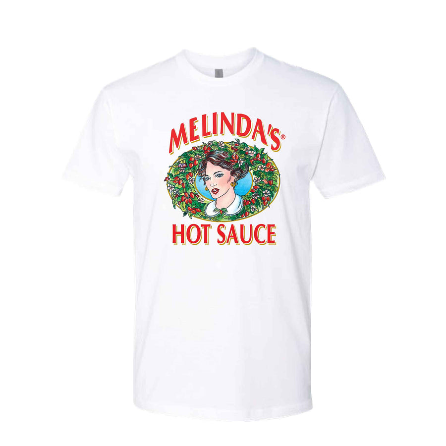 White t-shirt featuring Melinda's Hot Sauce logo with woman's portrait surrounded by colorful wreath of peppers and foliage