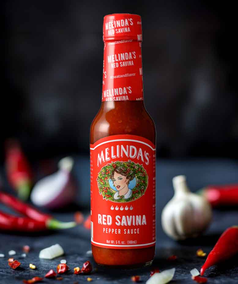 Melinda's Red Savina Pepper Sauce bottle with red label featuring woman's portrait, surrounded by chili peppers and garlic