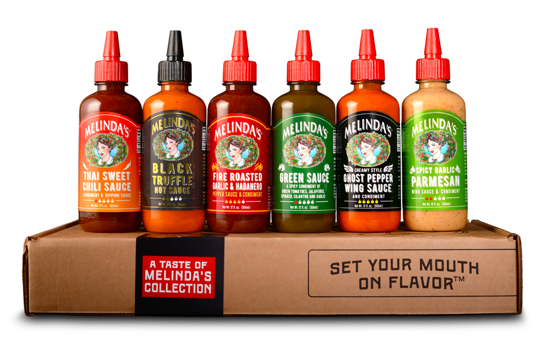 Six bottles of Melinda's hot sauce varieties displayed on cardboard box with "A Taste of Melinda's Collection" label