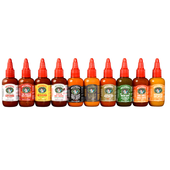 Ten Melinda's hot sauce bottles in a row with red caps, featuring various flavors like Cayenne, Fire Roasted Garlic, and...